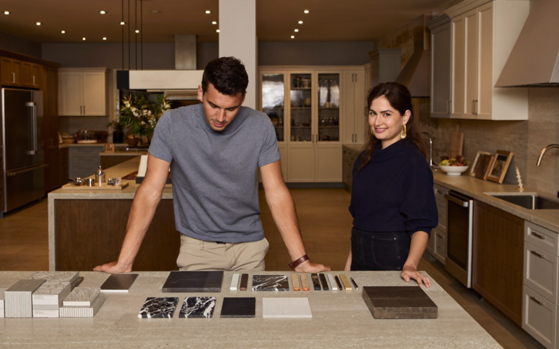 Kitchen and bath designer reviewing stone samples with a couple, kitchen showroom follow-up in action