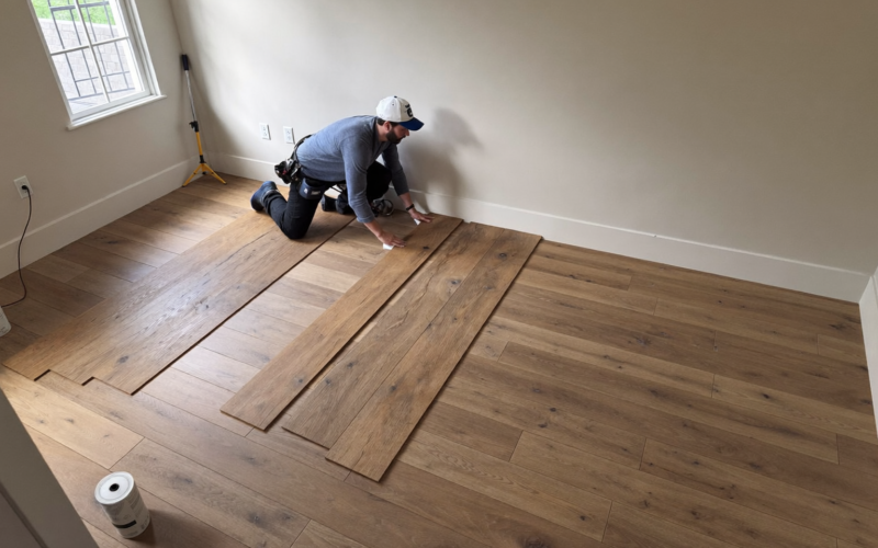 Flooring installer laying hybrid planks on schedule, flooring installer scheduling done right
