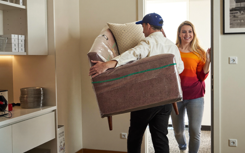 Delivery team bringing a sofa into a home, furniture store special orders delivered on time