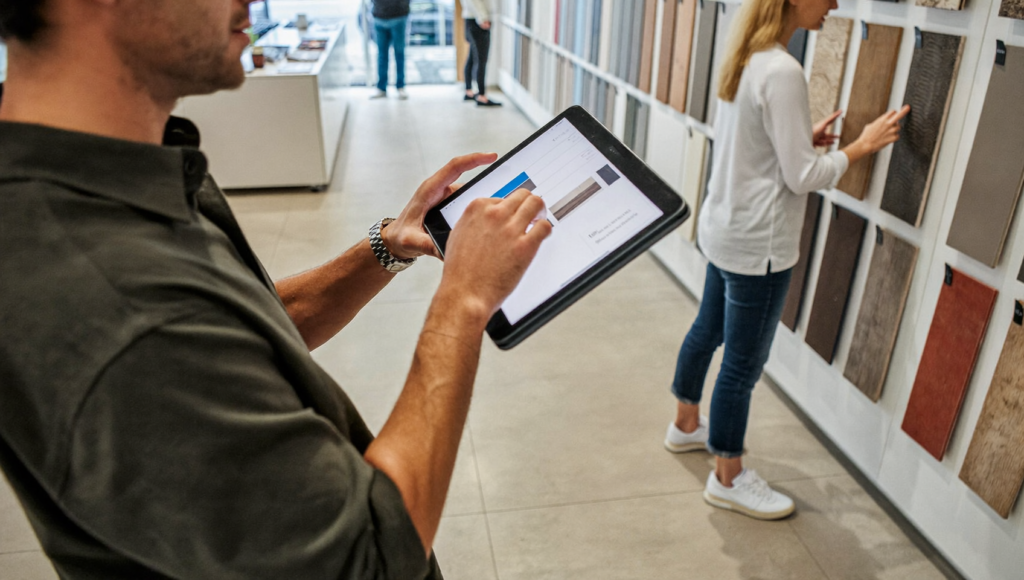 Flooring salesperson using a tablet beside sample boards, practical AI for flooring stores
