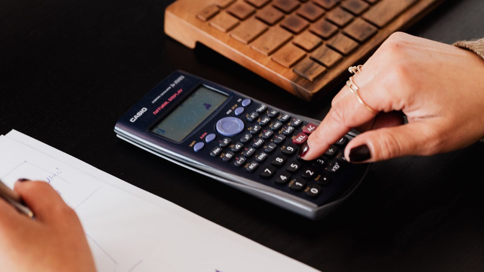 Bookkeeper checking job costs with a calculator to protect flooring store profit margin